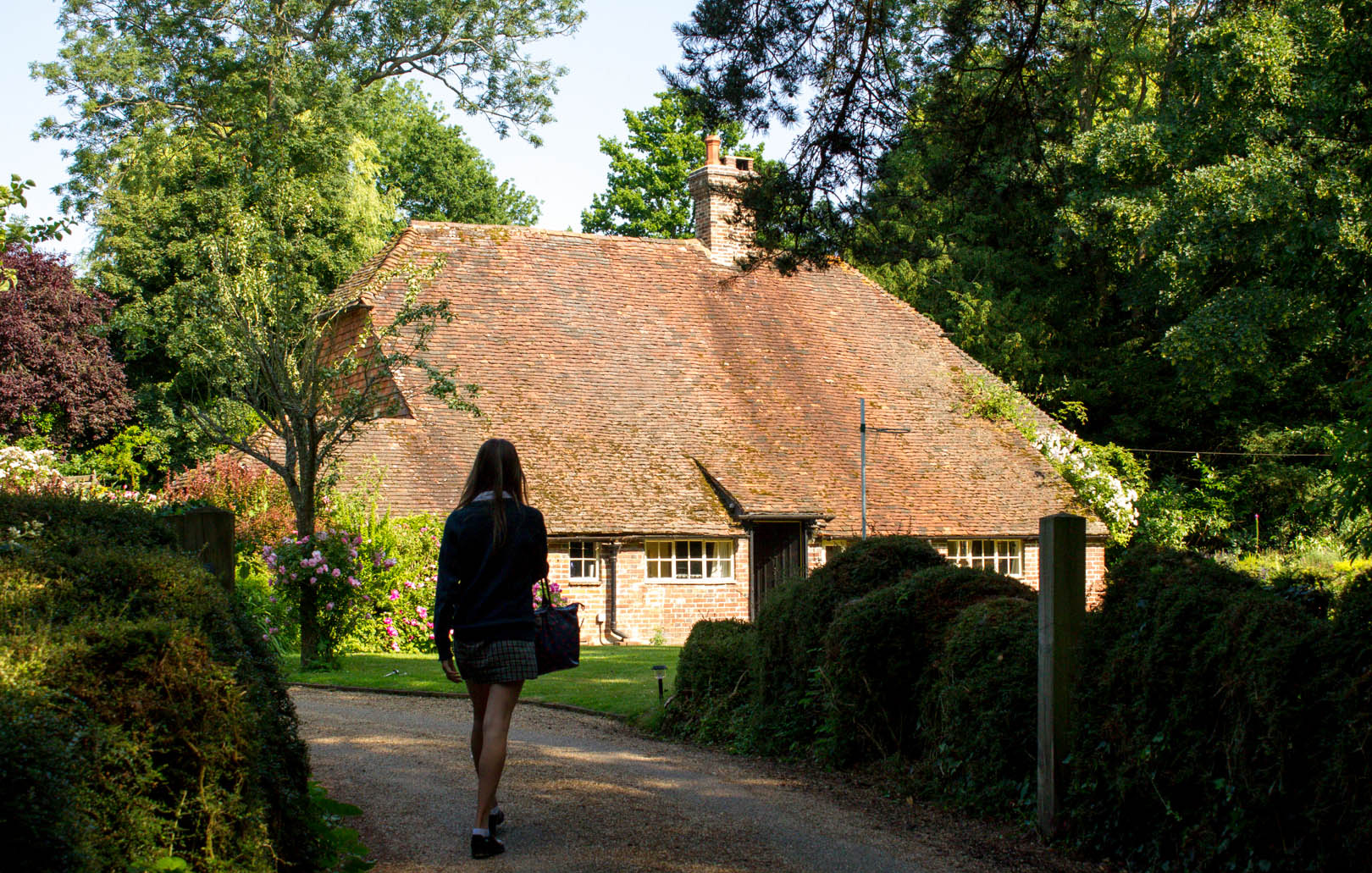 girl returning home to high roofed house